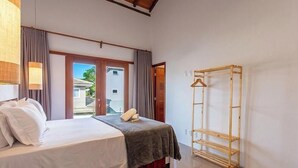 A hotel room with a bed, a wooden wardrobe, and a view of the outside. - House w/ Private Pool in Alto da Pitinga Ptg0003 (Porto Seguro)
