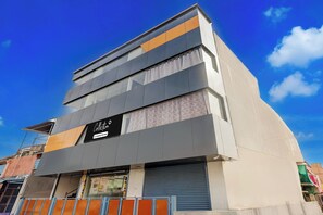 A multi-story building with a sign indicating it is a company-serviced collection point.