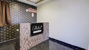 Een receptiegedeelte met een wand met een geometrisch patroon, een klok en een bord waarop 'Aanlevering' en 'Bedrijfsservice' staan.
