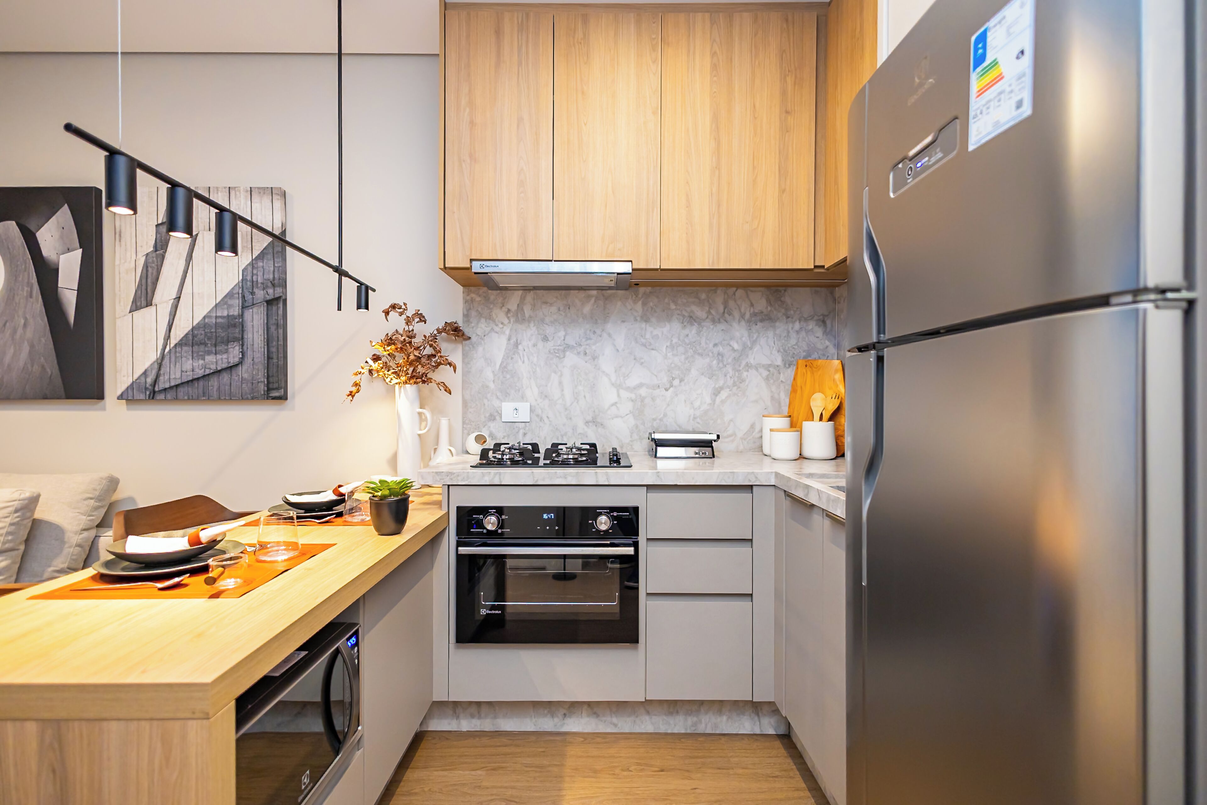Una cocina moderna con horno empotrado, refrigerador y estufa a gas.
