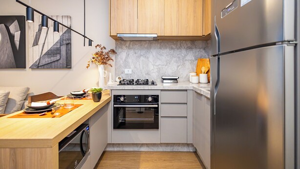Eine moderne Küche mit Einbauofen, Kühlschrank und Gasherd.