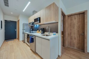 Eine moderne Küche mit integriertem Mikrowellenherd, Edelstahlgeräten und einem Holzkasten.