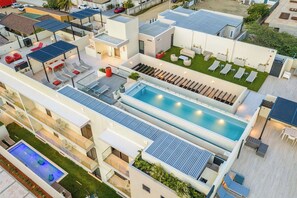 Ein modernes Hotel mit Dachpool, mehreren Lounges und einem gepflegten Garten.