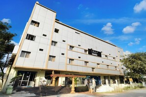 A multi-story building with a flat facade, multiple windows, and a sign indicating it is a company serviced location. - Super Collection O Godavari Kompally (Hyderabad)