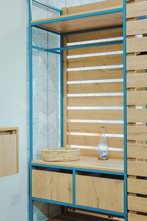 A wooden shelf unit with a woven basket and a glass bottle. - Bonsai Studio-Tranquil 103 (Noord)