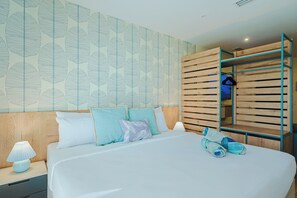 Une chambre moderne avec un grand lit, une tête de lit en bois, une armoire avec un miroir et un mur orné d’un motif de feuilles.