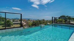 A clear blue swimming pool with a view of a residential area and mountains in the distance. - Studio in Center of Rosa, Rooftop w/ Pool Rso0010 (Imbituba)