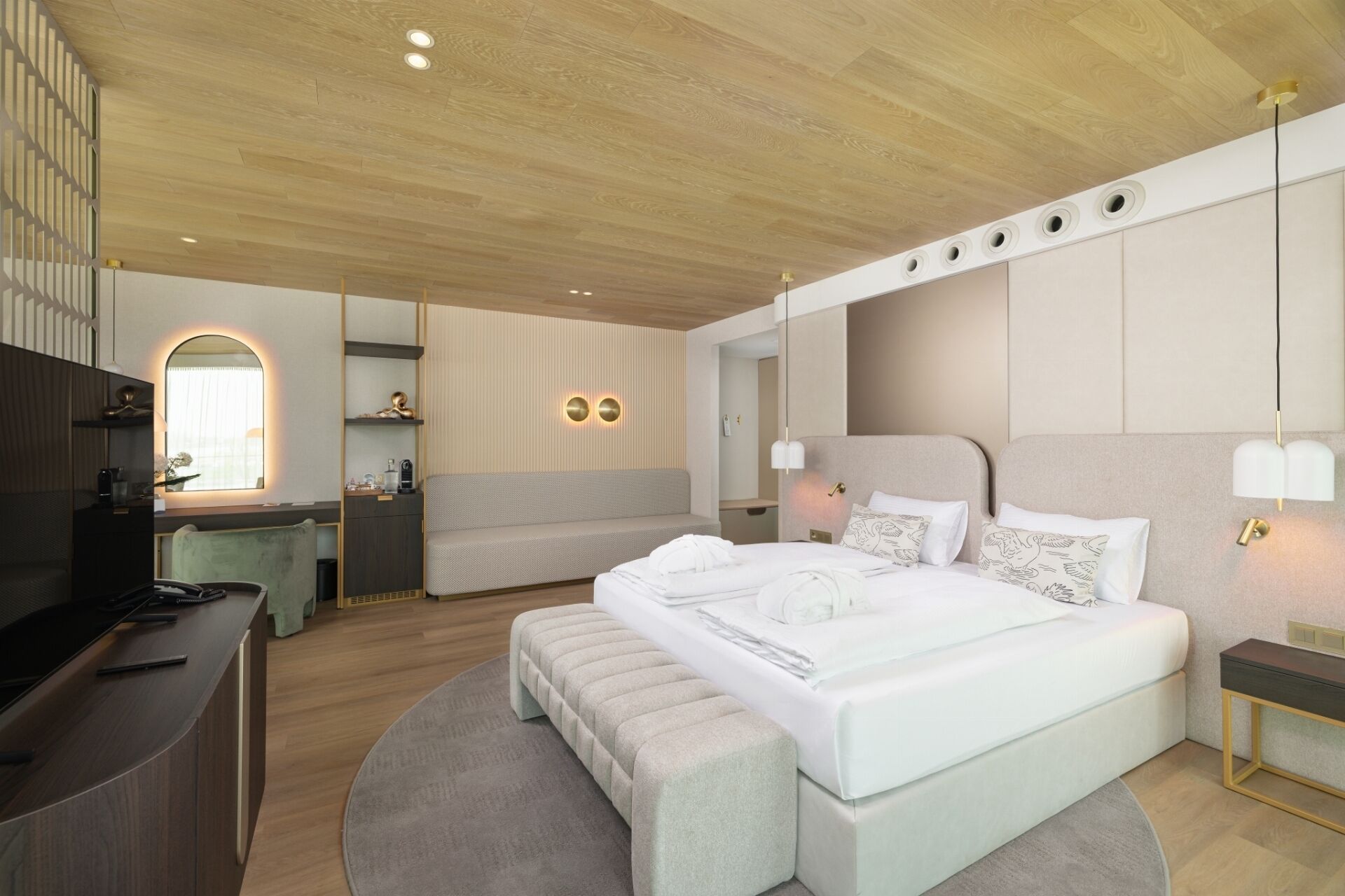 Una habitación de hotel moderna con una cama grande, un escritorio y una zona de estar.