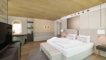 Una habitación de hotel moderna con una cama grande, un escritorio y una zona de estar.