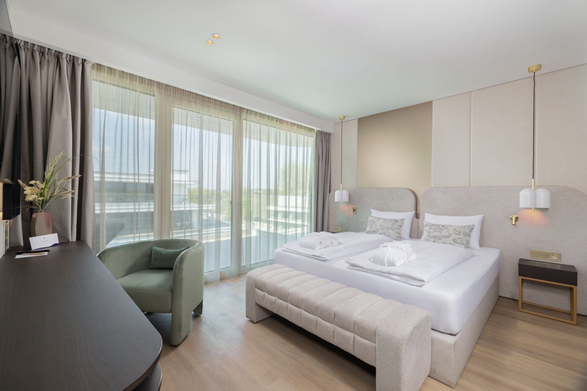 A modern hotel room with a large bed, a seating area, and a desk.