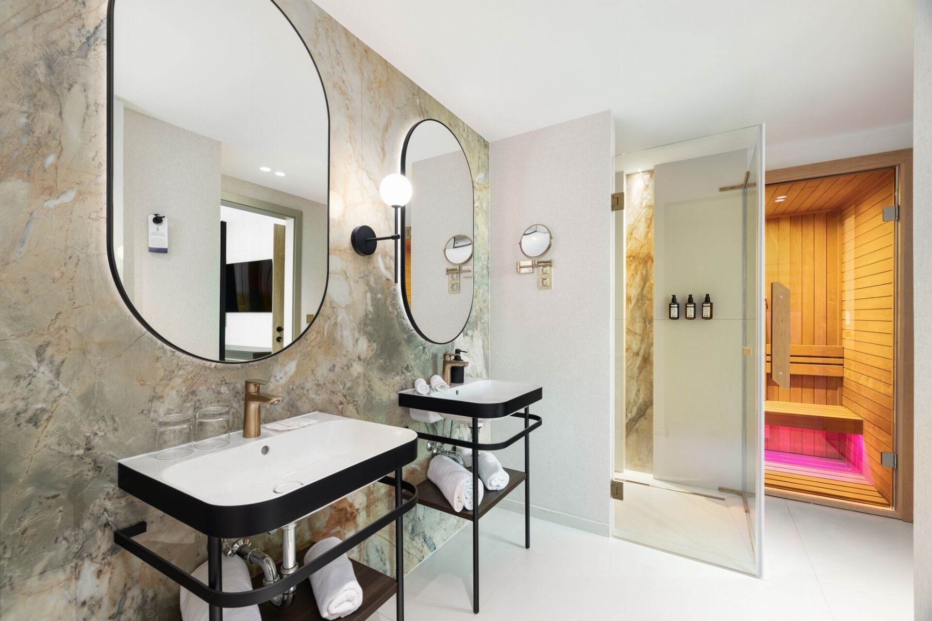 Een moderne badkamer met twee wasbakken, een grote spiegel en een douchecabine van glas.