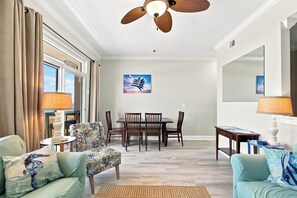 Ein Wohnzimmer mit Essbereich, Deckenventilator und einem Bild von einem Flugzeug.
