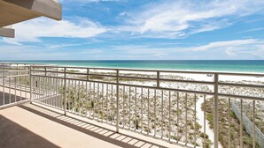 Ein Balkon mit Blick auf Strand und Meer.