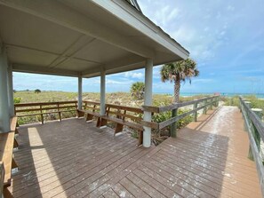 A wooden deck with benches, a covered area, and a view of the beach. - Susie's LGI - Free Ferry + Golf Cart + Pool (Placida)