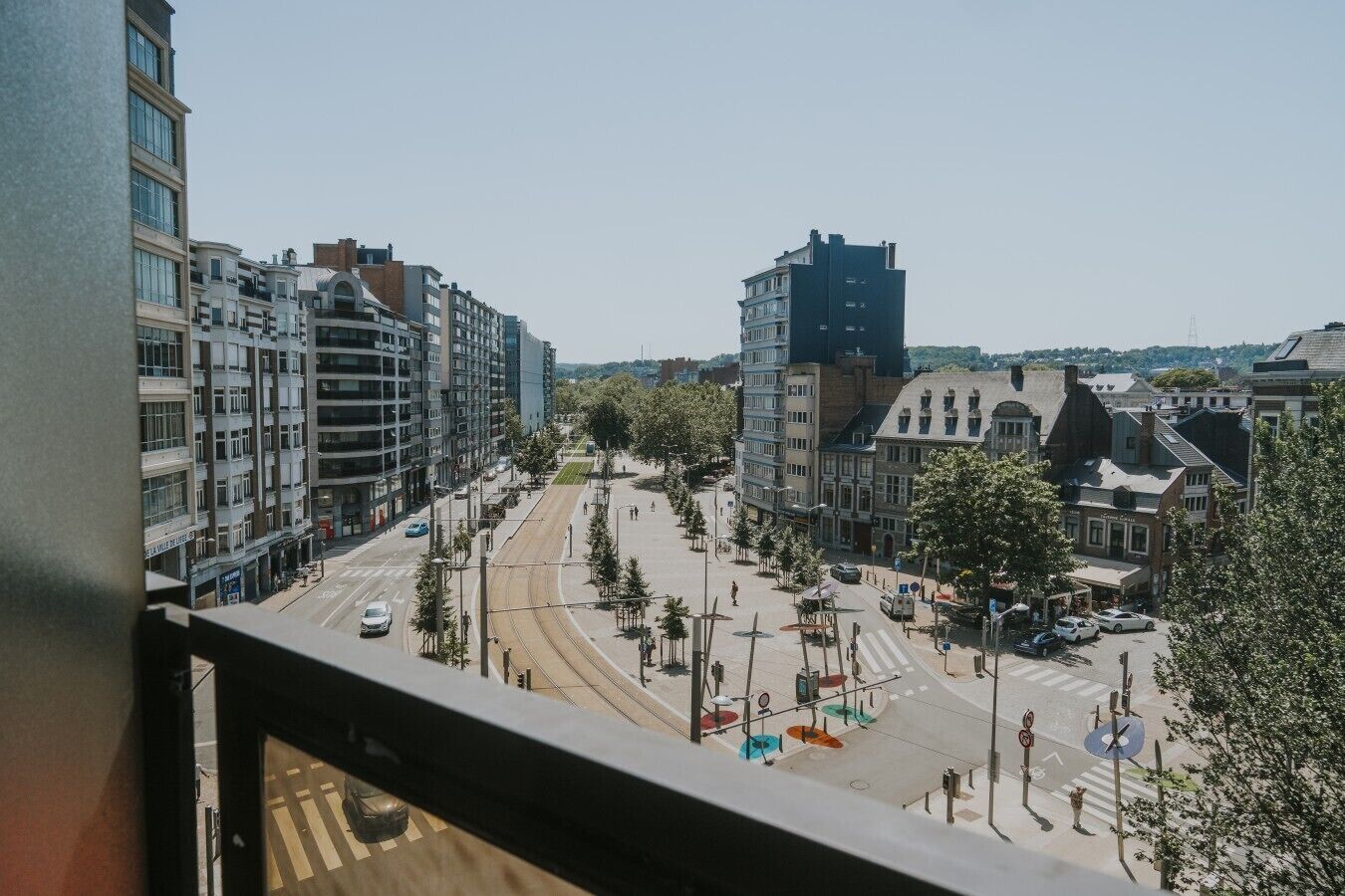 Una calle urbana con edificios, una línea de tranvía y un paso de peatones.