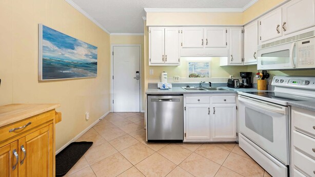 A kitchen with white cabinets, stainless steel appliances, and a tiled floor. - Lagoon View Villa Near Beach and Tennis (Hilton Head Island)