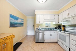 A kitchen with white cabinets, stainless steel appliances, and a tiled floor. - Lagoon View Villa Near Beach and Tennis (Hilton Head Island)