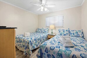 A bedroom with two beds, a ceiling fan, a window with blinds, and a bedside table with a lamp. - Lagoon View Villa Near Beach and Tennis (Hilton Head Island)