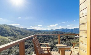 A wooden deck with a bench and table overlooking a mountainous landscape. - Cabin With hot tub and Mountain View Vst030 (Anitapolis)