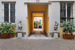 A corridor with statues on either side, leading to a building entrance. - Moscova Boutique - One Apartment with Wi-Fi and Air Conditioning (Milan)