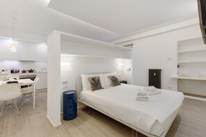 A modern hotel room with a bed, bedside table, and a view of the kitchen area. - Moscova Boutique - One Apartment with Wi-Fi and Air Conditioning (Milan)