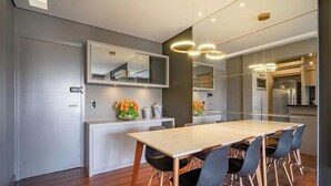 A modern kitchen with a large island, built-in appliances, and a dining area with a table and chairs. - Apt. in Condo. w/ Pool & Garage Pea0410 (Florianópolis)