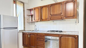 Une cuisine dotée de meubles en bois, d’un réfrigérateur en acier inoxydable, d’un lave-vaisselle et d’une cuisinière à gaz.