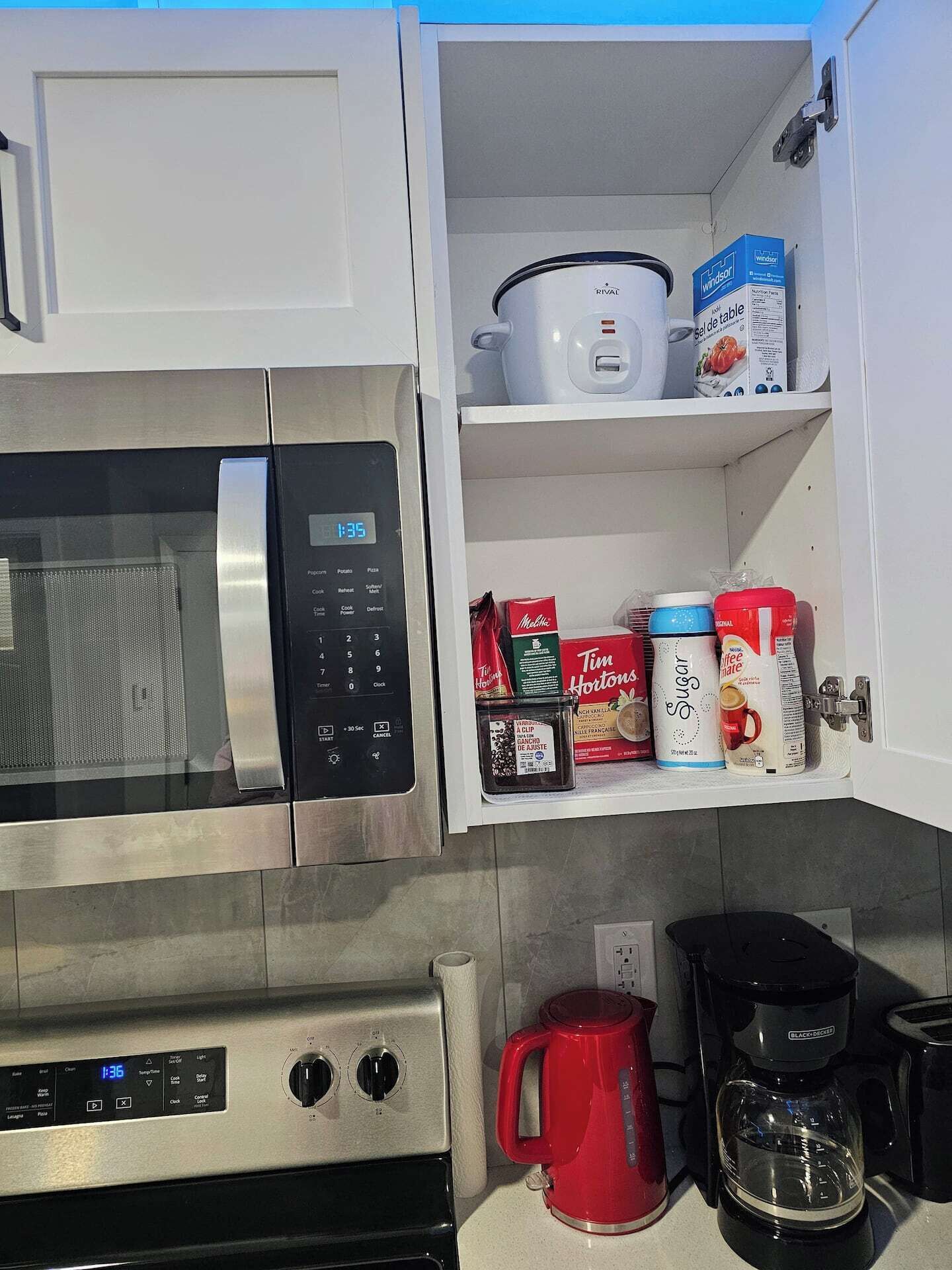 A kitchen with a microwave, oven, and a coffee maker.