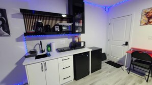 A compact kitchen with a white countertop, black appliances, and blue LED strip lighting. - SwitHome Cher Cozy Studio: Pond View, Near YEG Airport (Edmonton)