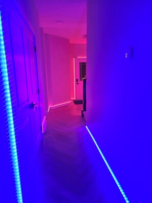 Ein Flur mit LED-Bandbeleuchtung entlang der Wände.