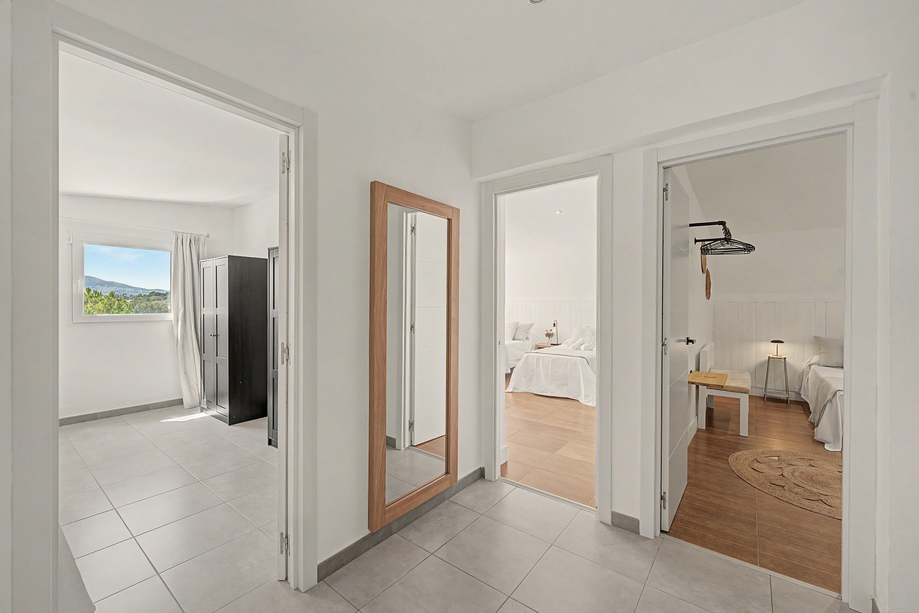 Habitación de hotel con balcón, cama, escritorio y silla.
