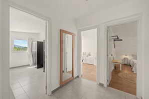 Habitación de hotel con balcón, cama, escritorio y silla.