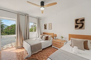 A bedroom with a bed, a nightstand, a lamp, and a view of the outdoors. - Villa 'Finca Raziel' with Pool, Mountain Views, and Wi-Fi (Cártama)