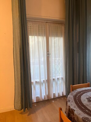 A room with a sliding glass door, a wooden table, and a patterned tablecloth. - Casa Baba Apartment – Great Location in Rapallo, Ligurian Riviera (Rapallo)