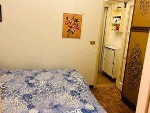 A room with a bed, a painting, a wardrobe, and a door leading to a bathroom. - Casa Baba Apartment – Great Location in Rapallo, Ligurian Riviera (Rapallo)