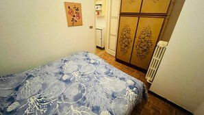 Une chambre à coucher avec un lit, une armoire et un radiateur.