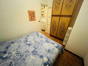Ein Schlafzimmer mit einem Bett, einem Kleiderschrank und einer Heizung.