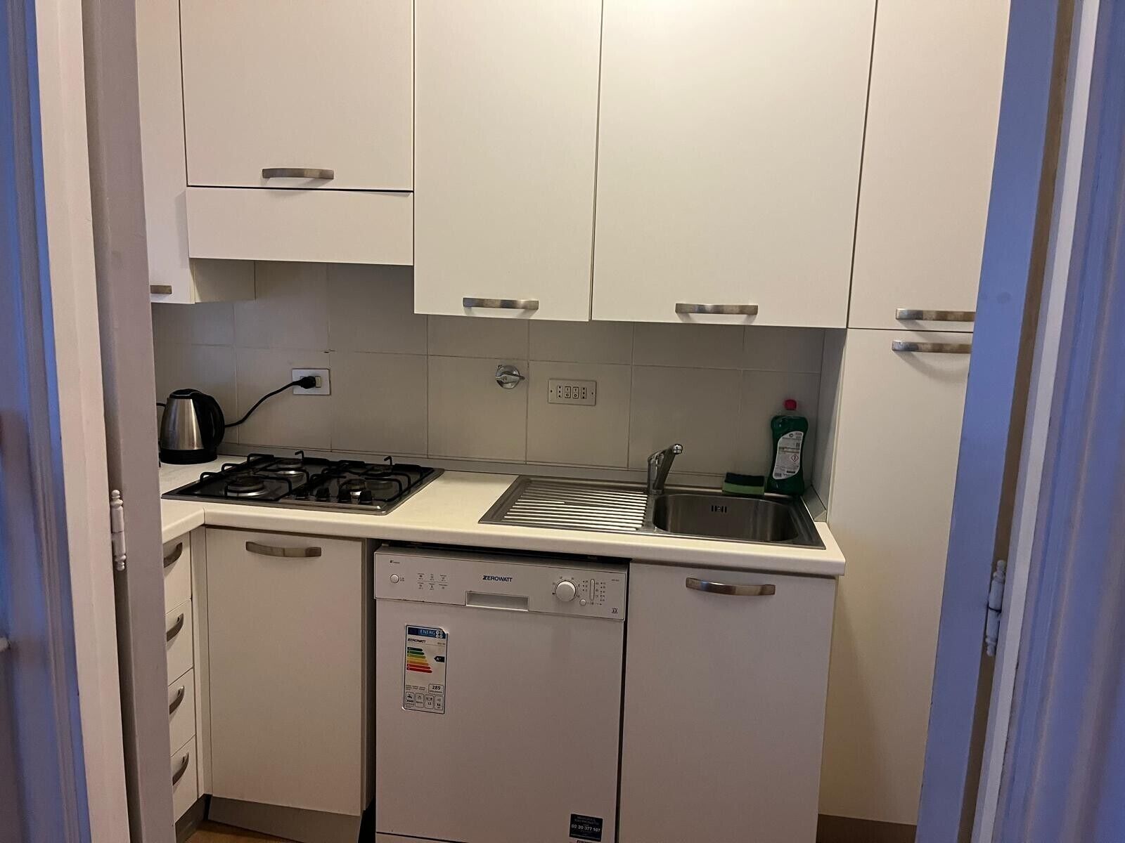 A compact kitchen with a gas stove, a dishwasher, and a sink.