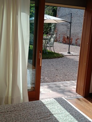 A room with a wooden door leading to an outdoor patio area.