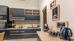 A modern kitchen with built-in appliances, a coffee machine, and a chalkboard sign. - Boutique Apartment (Toscolano Maderno)