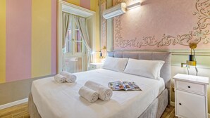 A hotel room with a bed, a nightstand, a lamp, and a window with curtains. - Boutique Apartment (Toscolano Maderno)