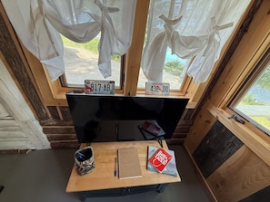 A room with a wooden desk, a television, a notebook, and a book titled 'Bulls on a Mission.'