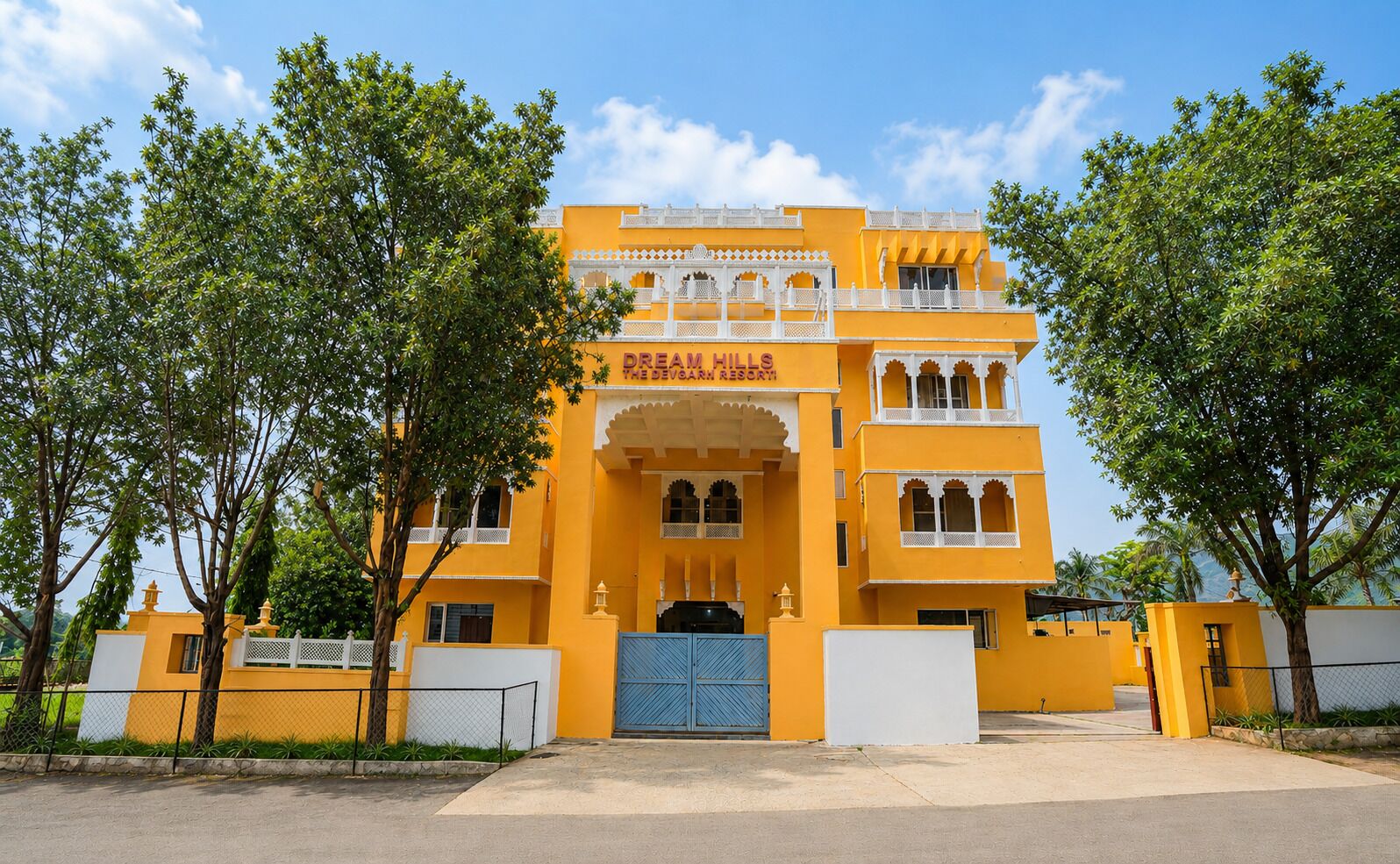 Un edificio amarillo con un letrero que dice 'Dream Hills The Devghar Resort'.