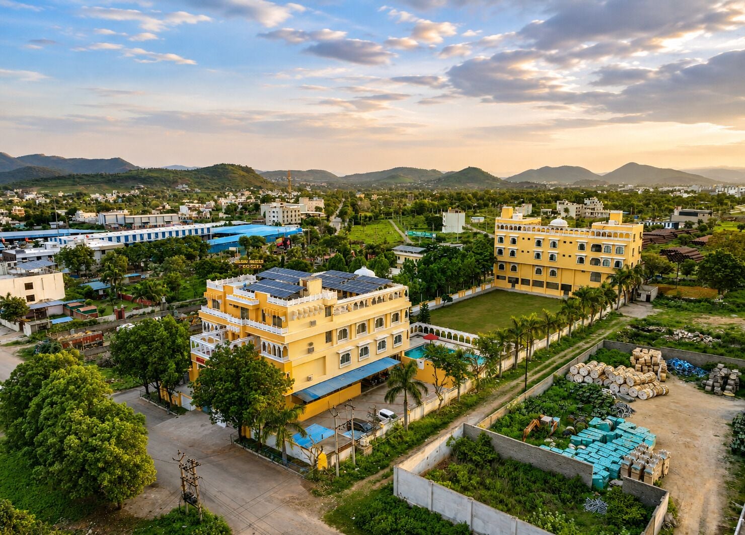 Zona residencial con varios edificios, incluyendo una casa amarilla de varios pisos con piscina y paneles solares.