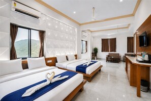 A hotel room with two beds, a desk, a TV, and a view of the outdoors. - The Dream Hills Resort – A Scenic Mountain View Retreat, Udaipur (Udaipur)