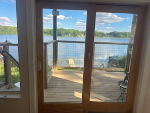 A wooden deck with a view of a lake and a house in the background.
