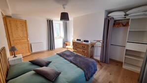 Un dormitorio con cama, cómoda y armario.