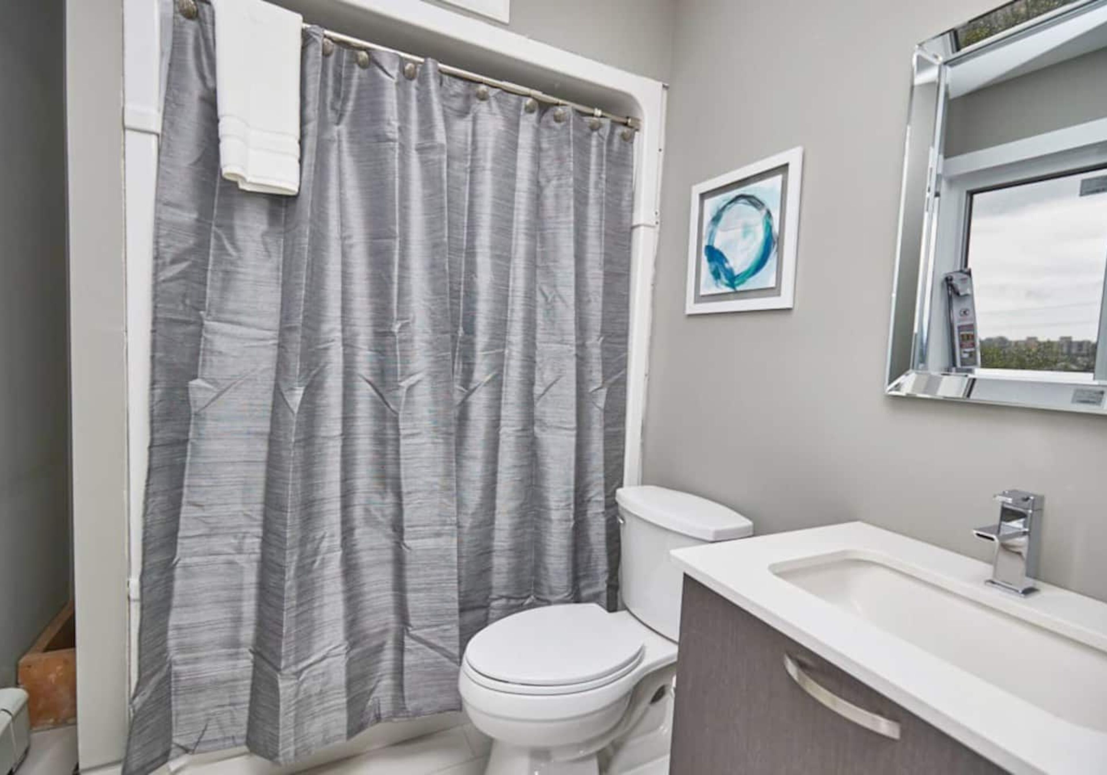 A bathroom with a toilet, a sink, and a shower curtain.