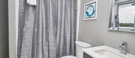 A bathroom with a toilet, a sink, and a shower curtain.