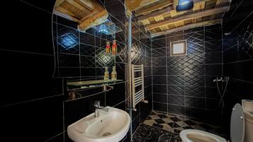 Um banheiro com piso quadriculado em preto e branco, pia branca e vaso sanitário.